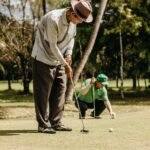 Two senior men playing golf on a sunny day, illustrating focus and sportsmanship.