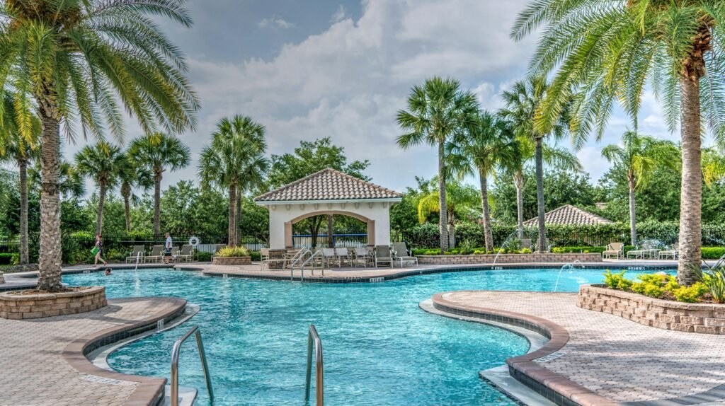 Relaxing tropical poolside scene with palm trees, gazebo, and clear blue water at a luxury resort.